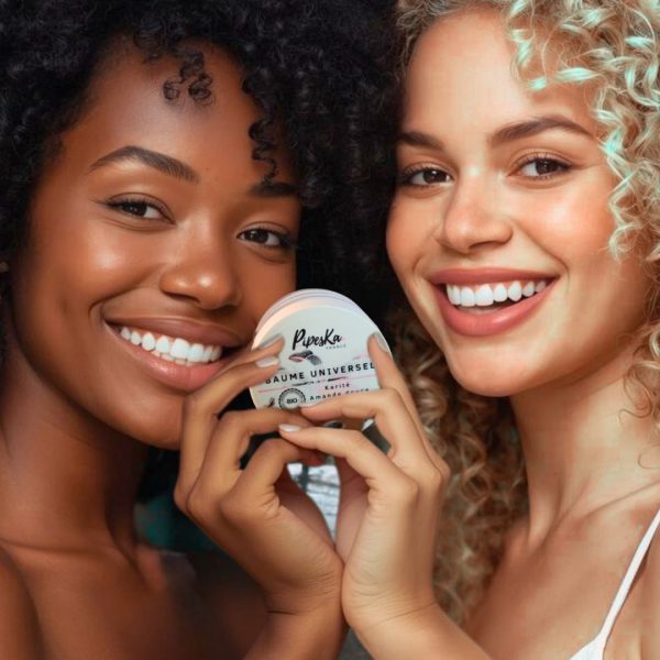 Deux femmes, cheveux texturés, utilisant le Baume Universel Bio Caribbean Fusion – soin naturel et multi-usage.